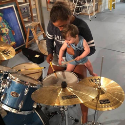 Myaddy with kid playing drums.